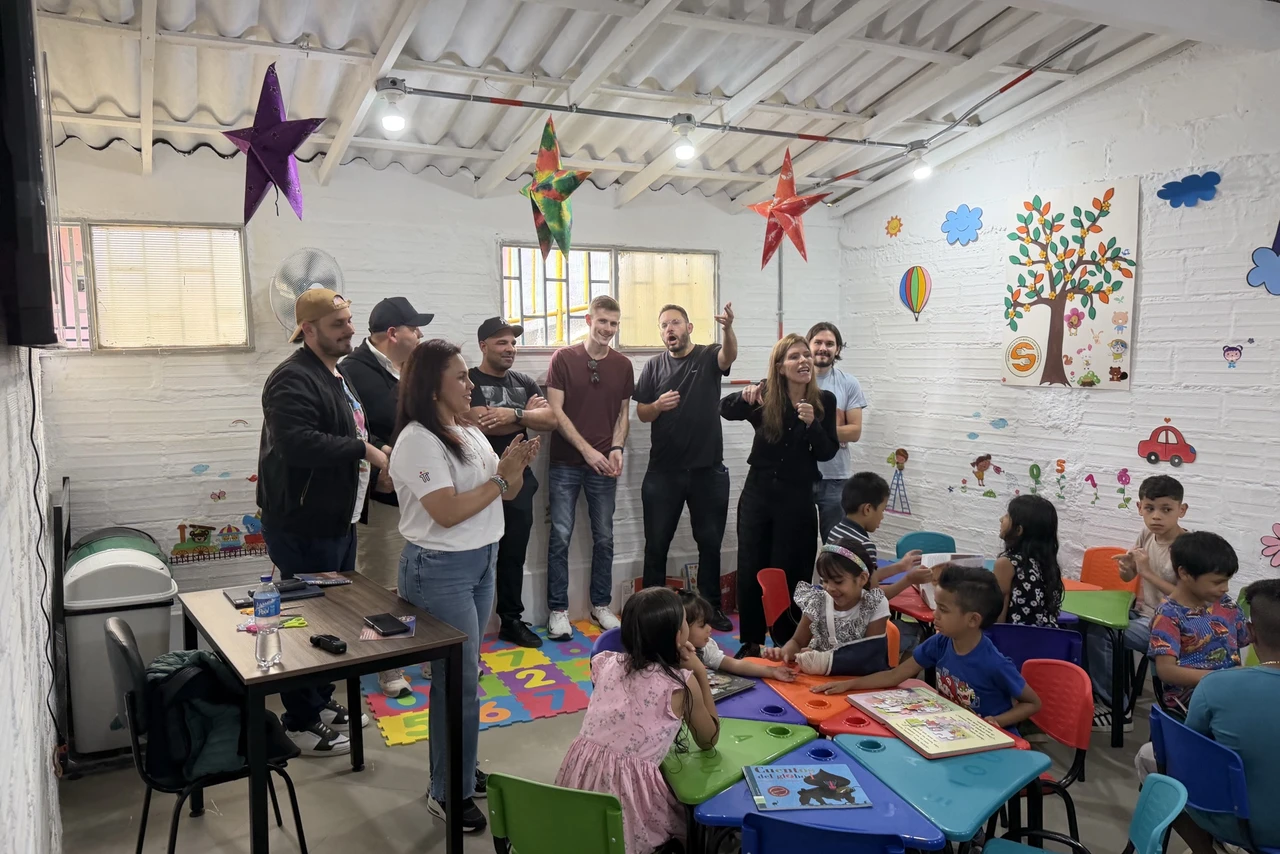 Volunteers and children gathered in a brightly decorated classroom